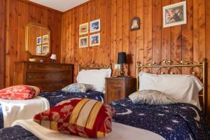 two beds in a room with wood paneled walls at Residenza Le Fontane in Ceppo Morelli