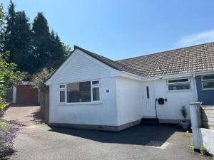 a small white house with a driveway at Bungalow on Dartmoor's Edge, Parking & Garden in Ashburton