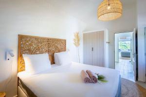 une chambre avec un grand lit blanc avec deux serviettes dessus dans l'établissement Villa Stoney Coral 17 - Coral Estate, à Willibrordus 9 autres photos