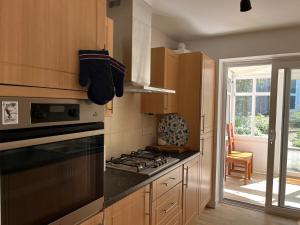 Una cocina con gabinetes de madera y un horno de estufa. en Bungalow on Dartmoor's Edge, Parking & Garden, en Ashburton 16 fotos más