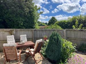 a wooden table and chairs in a garden at Bungalow on Dartmoor's Edge, Parking & Garden in Ashburton