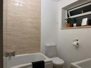 Un baño con bañera, inodoro y lavabo. en Bungalow on Dartmoor's Edge, Parking & Garden, en Ashburton