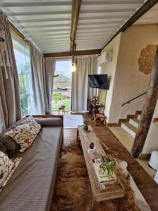 a living room with a couch and a table at Chalé Girassol - Vila Monte Cunha in Cunha