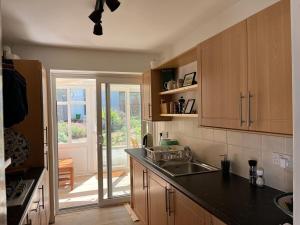 Una cocina con fregadero y puerta a un patio. en Bungalow on Dartmoor's Edge, Parking & Garden, en Ashburton