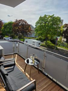a balcony with a table and chairs on a roof at Design-Apartments I Klimaanlage I Boxspring I Nespresso I Parklplatz in Weil am Rhein