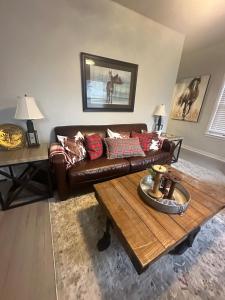 ein Wohnzimmer mit einem braunen Ledersofa und einem Couchtisch in der Unterkunft The Birchwood - At Twin Pines-Walk to the Lake! in Clear Lake