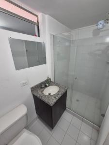 a bathroom with a sink and a shower and a toilet at Cuarto amoblado en la Loma del Indio, El Poblado con vista a la ciudad in Medellín