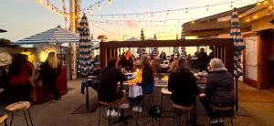 een groep mensen die aan tafels op een terras zitten bij West Beach Villa 6 in Santa Barbara