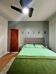 a bedroom with a large bed with a ceiling fan at APTO 401 - no centro, pertinho de tudo in Poços de Caldas +36 photos