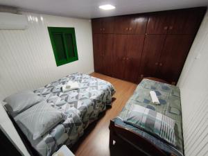 Un dormitorio con dos camas y un banco en él. en Casa Sander Gramado, en Gramado