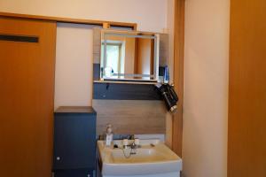ein Badezimmer mit Waschbecken und Spiegel in der Unterkunft LYS AIBA House - Japanese Garden Villa - Vacation STAY 79096v in Aiba + 9 Fotos