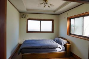 ein Schlafzimmer mit einem Bett und zwei Fenstern in der Unterkunft LYS AIBA House - Japanese Garden Villa - Vacation STAY 79096v in Aiba