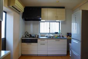 eine Küche mit weißen Schränken und einem weißen Kühlschrank in der Unterkunft LYS AIBA House - Japanese Garden Villa - Vacation STAY 79096v in Aiba