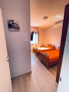 a room with two beds with orange sheets at Afficamere Mattia Mottola 1 in Fiumicino