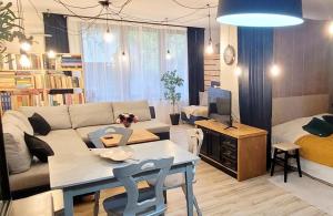 a living room with a couch and a table at Apartament Szpilka - domek in Police