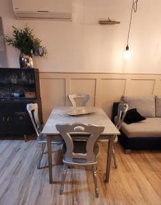 a table and chairs in a living room with a couch at Apartament Szpilka - domek in Police +16 photos