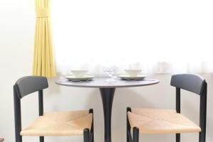 ein Tisch mit zwei Stühlen und ein Tisch mit Gläsern darauf in der Unterkunft Fontaine Kamata - Vacation STAY 79340v in Tokio + 14 Fotos