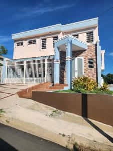 Humacao Puerto Rico house sleeps 8 في هوماكاو: بيت ابيض امامه سياج
