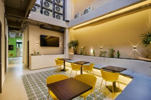 a restaurant with tables and chairs and a tv at Hotel Attic 33 in Medellín