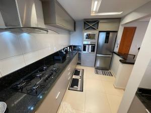 a kitchen with stainless steel appliances and a black counter top at Impecável Cobertura em Paraíso in Luis Eduardo Magalhaes
