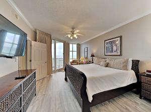 una camera da letto con un letto grande e una televisione di Palacio Unit 403 a Perdido Key