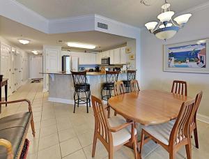 una sala da pranzo e una cucina con tavolo e sedie di Palacio Unit 403 a Perdido Key Altre 31 foto