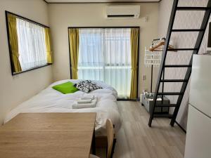 ein kleines Schlafzimmer mit einem Bett und einer Leiter in der Unterkunft Corpo SKR201 - Vacation STAY 20556 in Kichijōji