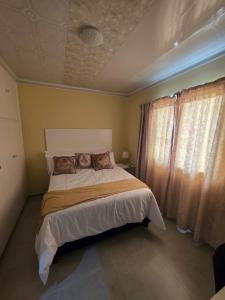 une chambre avec un lit avec deux oreillers dessus dans l'établissement Sweet Home Guest House, à East London