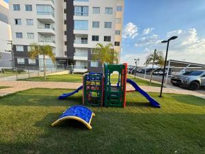 a playground in a park in front of a building at Impecável Cobertura em Paraíso in Luis Eduardo Magalhaes