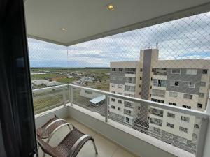 a balcony with two chairs and a view of a building at Impecável Cobertura em Paraíso in Luis Eduardo Magalhaes