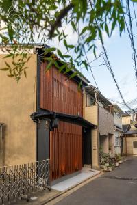 ein Gebäude mit einer Holztür und einem Zaun in der Unterkunft Kyoran [Phantom Flower Residence] - Vacation STAY 80036v in Kyōto