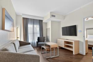 een woonkamer met een bank, een tv en een bed bij Homewood Suites by Hilton Carlsbad-North San Diego County in Carlsbad