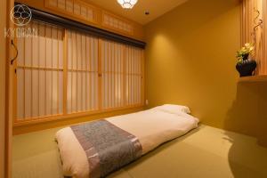 ein Schlafzimmer mit einem Bett in einem Zimmer mit einem Fenster in der Unterkunft Kyoran [Phantom Flower Residence] - Vacation STAY 80036v in Kyōto