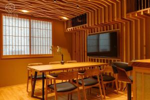 ein Esszimmer mit einem Holztisch und Stühlen in der Unterkunft Jinglan [Orchid Residence] - Vacation STAY 80077v in Kyōto