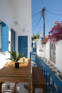 una mesa de madera en un balcón con puerta azul en Eleanna's Mykonos, en Mykonos ciudad