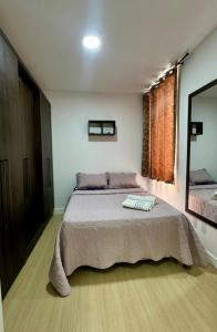 a bedroom with a large bed and a large window at Refúgio Amazônico com Piscina e Natureza in Manaus