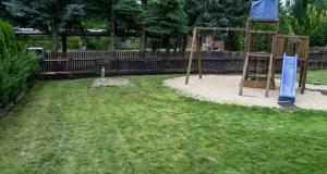 - une aire de jeux dans un parc avec une clôture en bois dans l'établissement Ferienhaus Sonnenseite-Rechts, nur 100m vom Senftenberger See, à Senftenberg