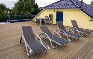 un groupe de chaises et une table sur une terrasse dans l'établissement Ferienhaus Sonnenseite-Rechts, nur 100m vom Senftenberger See, à Senftenberg