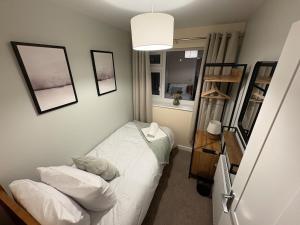 ein kleines Zimmer mit einem Bett und einem Regal in der Unterkunft Greenfield House - Keighley Eastburn in Kildwick