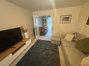 ein Wohnzimmer mit Couch und Flachbildfernseher in der Unterkunft Greenfield House - Keighley Eastburn in Kildwick