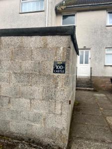 a sign on the side of a brick wall at 100 Castle in New Cumnock +4 photos