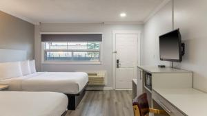 a hotel room with two beds and a flat screen tv at Motel 6 Cornwall Hwy 401 ON in Cornwall +40 photos