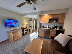 Una sala de estar con un sofá y una cocina. en Grand Lodge Crested Butte, en Crested Butte