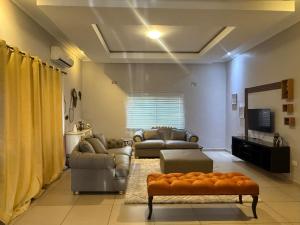 een woonkamer met 2 banken en een televisie bij Spacious Modern 3-Bedroom Foxdale in Foxdale Estates