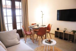a living room with a table with chairs and a tv at anthony meggy in Thiron-Gardais