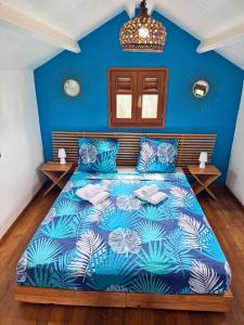 Un dormitorio azul con una cama con una pared azul. en Villa Tea Free, en Anse-Bertrand
