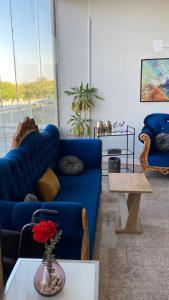 een woonkamer met een blauwe bank en een tafel bij فندق روز بلازا in Abha