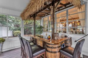温特黑文Sunrise on Lake Idylwild的一间有很多窗户的房间里的酒吧