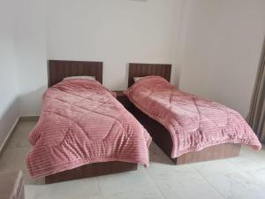 two beds sitting next to each other in a room at Mirage Bay Resort & Aqua Park in Hurghada