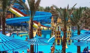 a water park with a water slide and palm trees at Mirage Bay Resort & Aqua Park in Hurghada